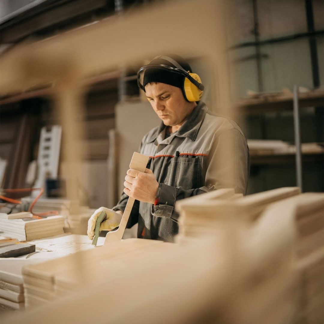 Trabajadores de Nüma ensamblando una pieza de madera con herramientas en un taller profesional